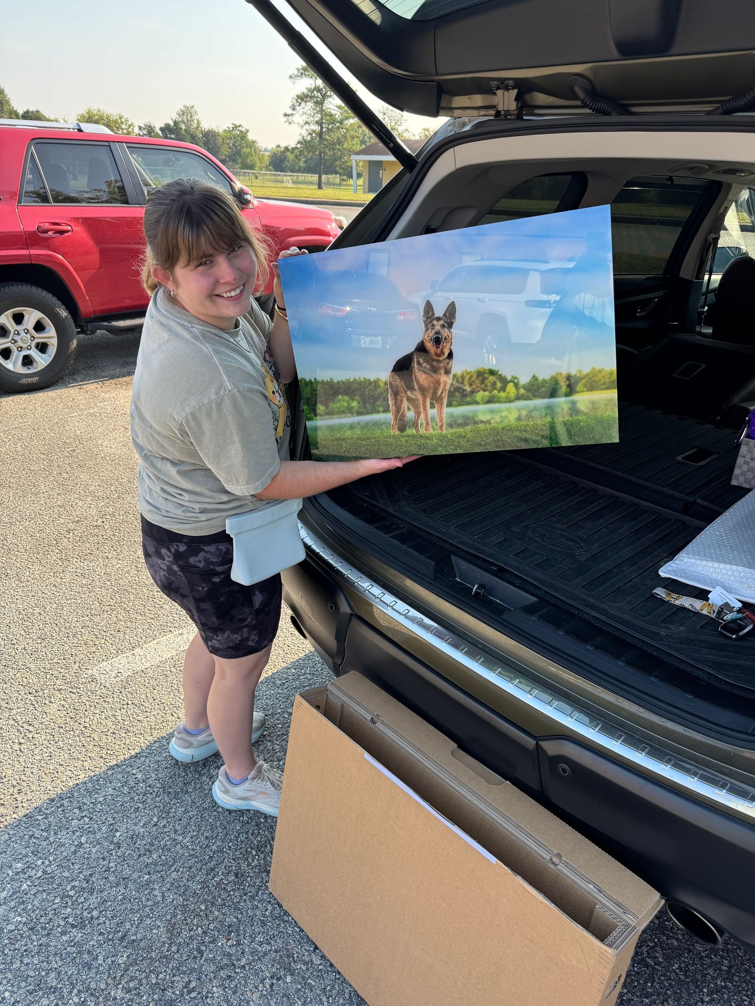 Ashley Summerville of Paws for Portraits holding wall art from graphi studio.