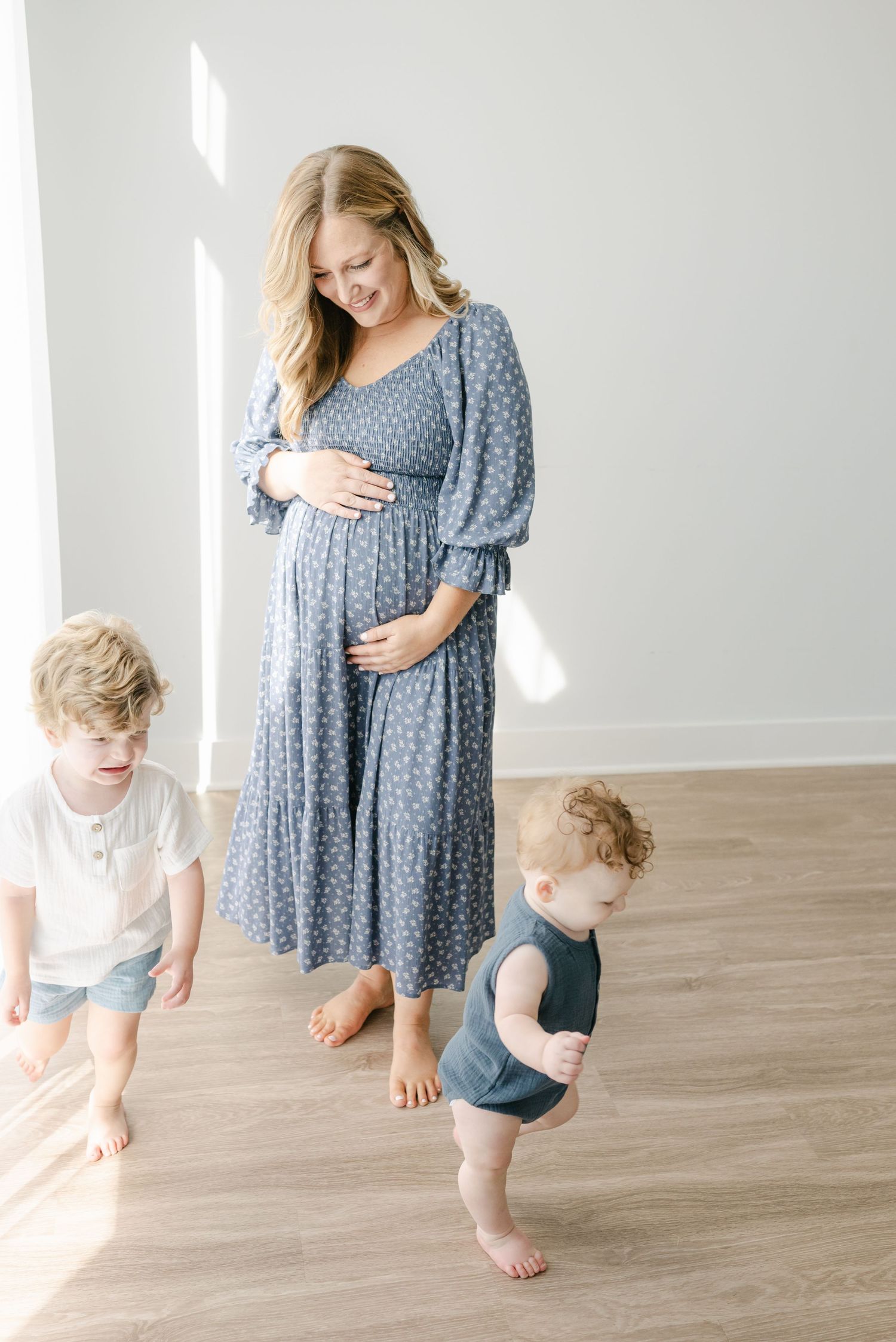 Mother and child playing together in a blue polka dot dress during indoor photoshoot.