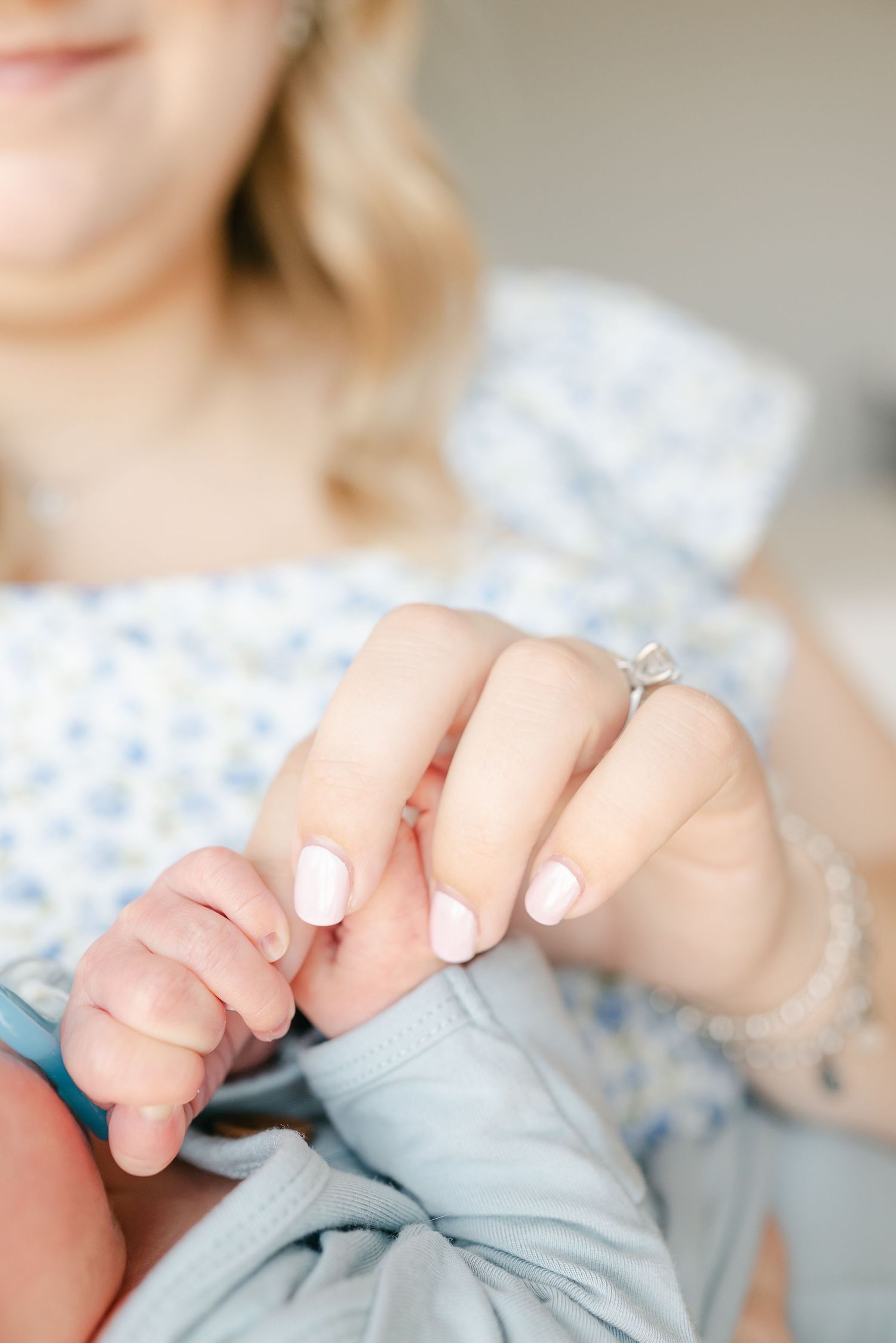 Close-up view of hands gently holding a soft blue and white patterned fabric.