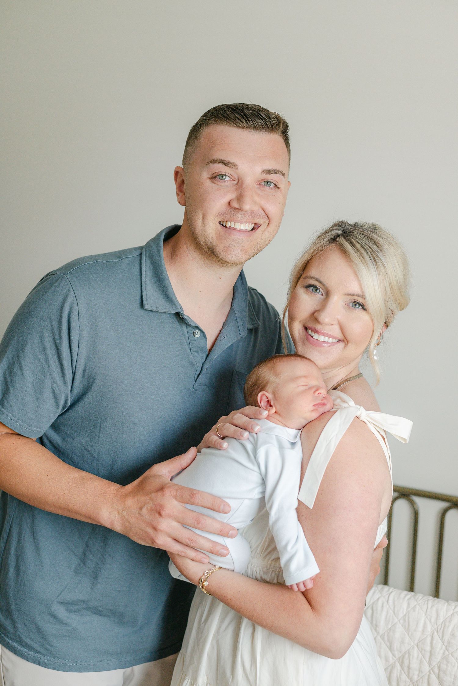 Family lifestyle portrait session with newborn in white nursery setting.