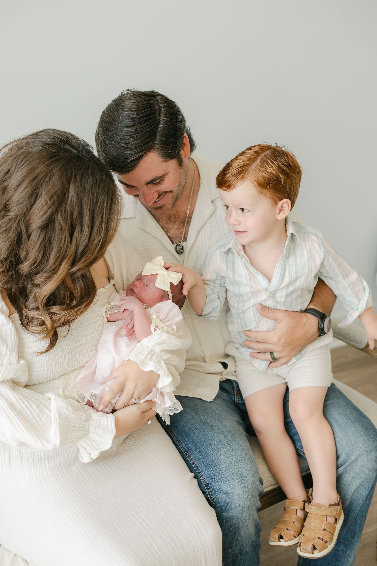 Family sitting together on floor sharing intimate moments with young child.