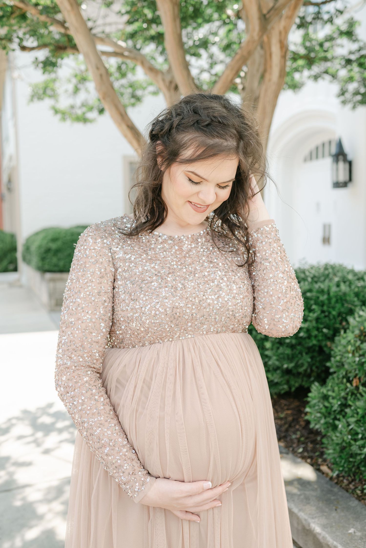 Close-up maternity photos in a sparkly beige dress against classic white architecture.