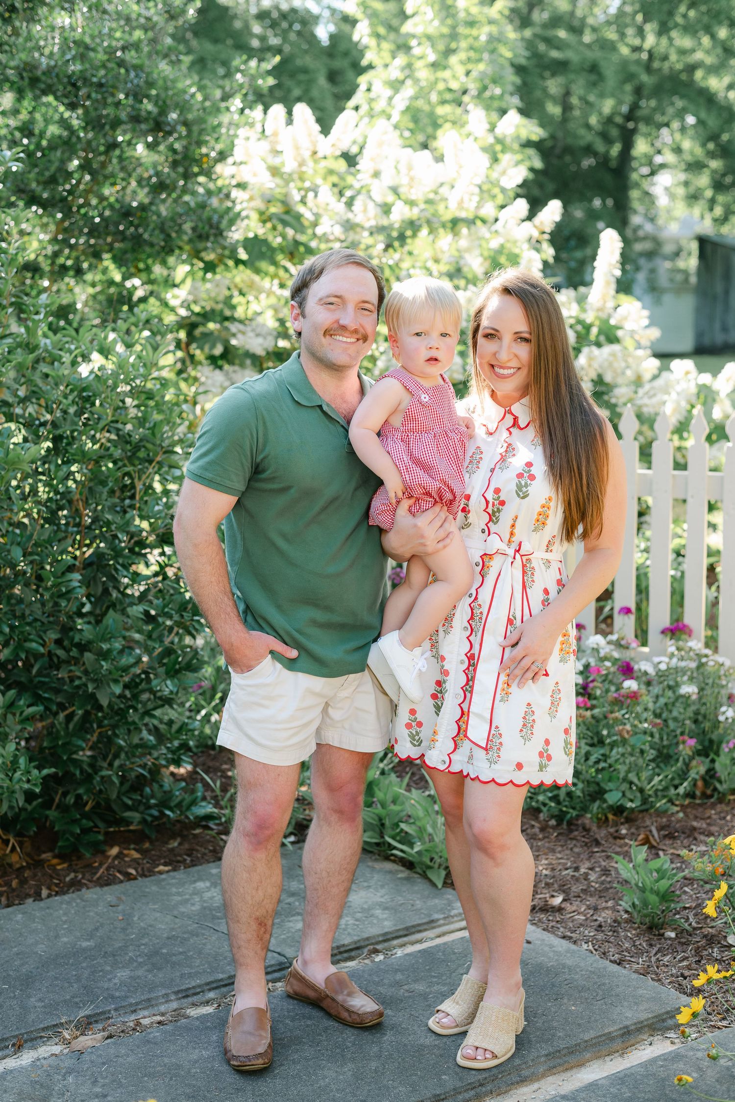 Family photos in garden setting with white picket fence and yellow flowers blooming.