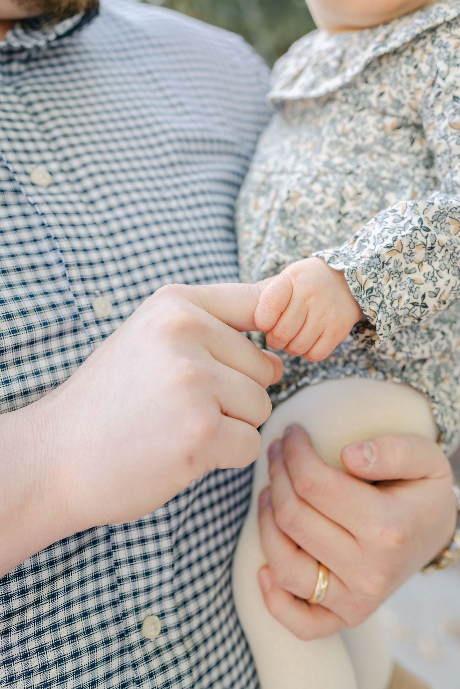 Close-up of holding hands showing tender connection between family members.