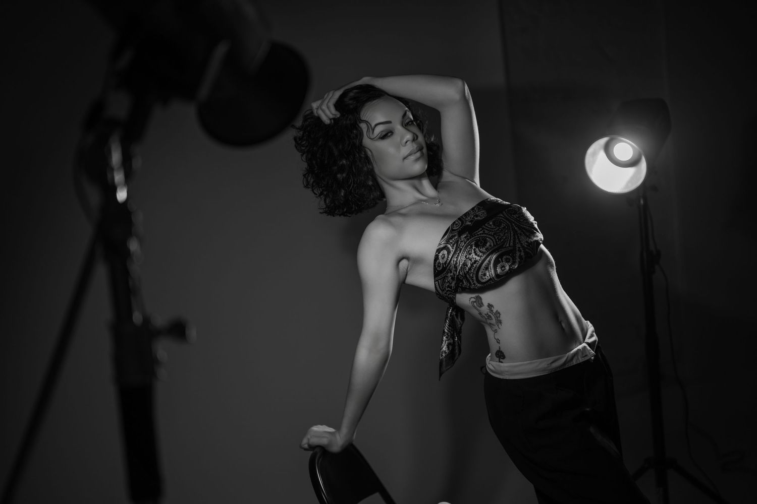 Black and white artistic photograph showing silhouettes of dancers in dramatic poses against dark background.