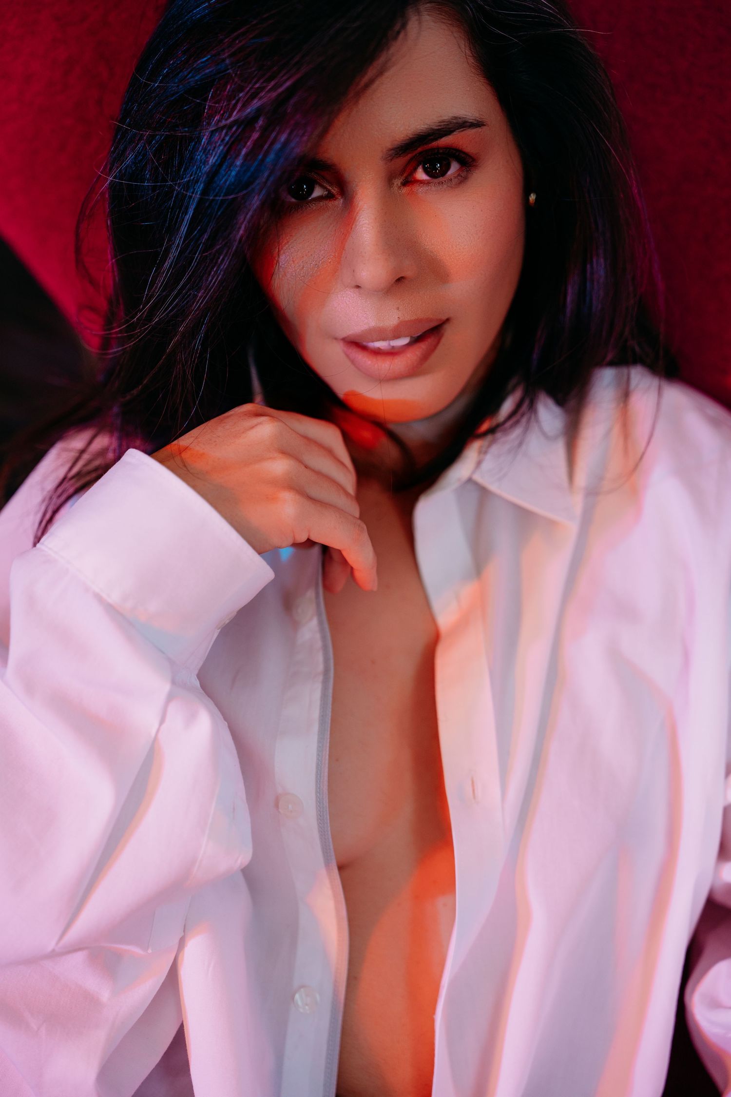 A series of seven photos showing someone in a white button-down shirt against a dark red background.