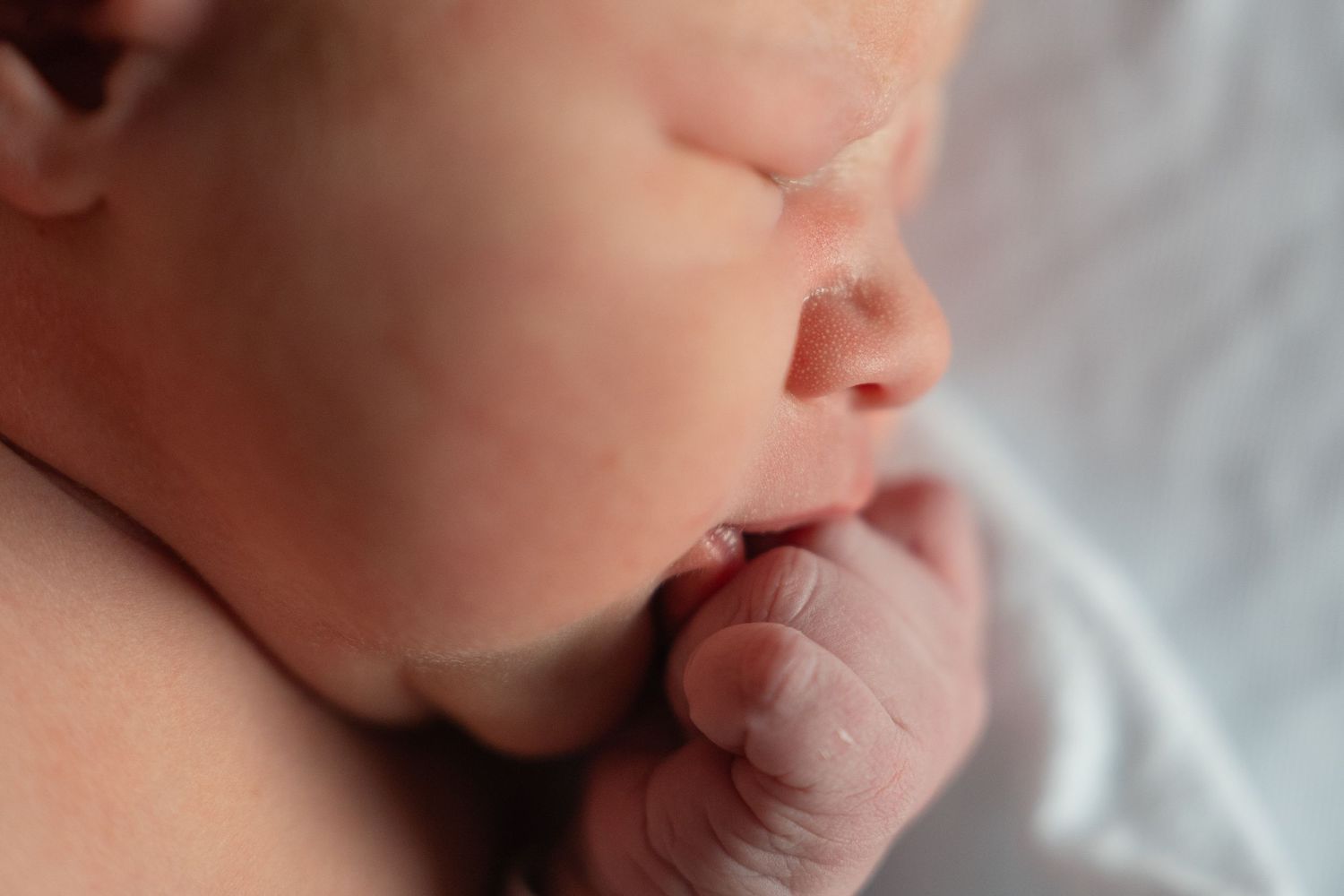 Close up of a sleeping newborn baby's face and mouth.