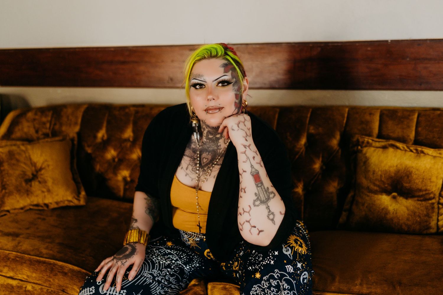 A person with green hair and tattoos poses in various artistic shots against dark rustic backgrounds.