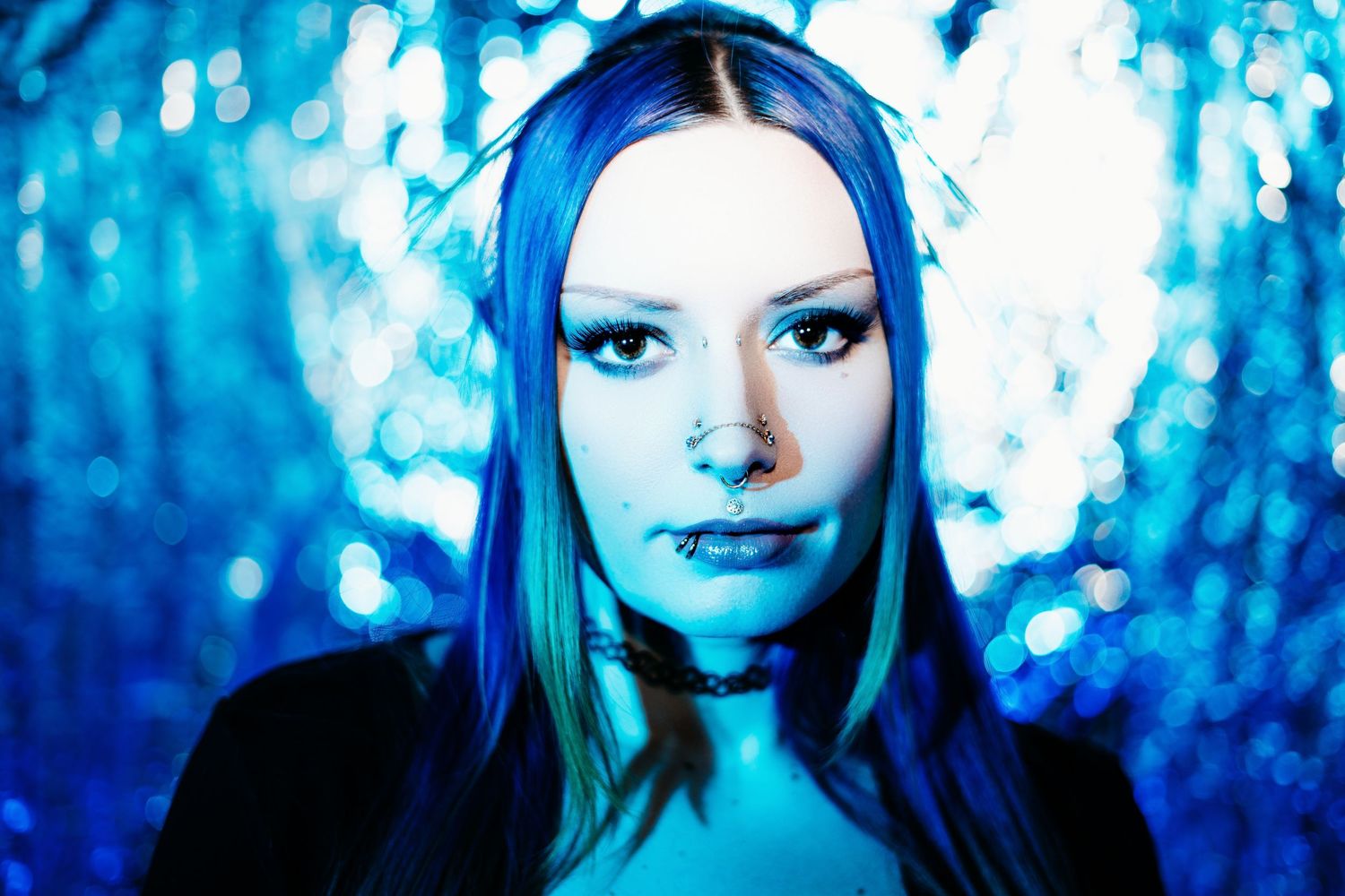 A blue-tinted artistic portrait series showing the same person in four similar poses against a dark background.