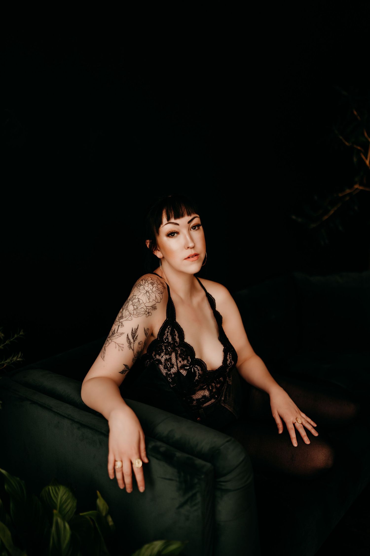 Artistic boudoir photography series shows dark moody portraits with dramatic lighting against a black background.