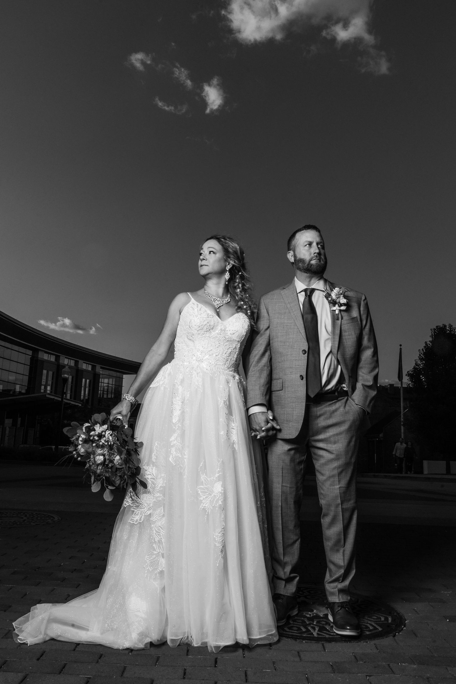 Black and white wedding photography series showing couple in formal attire posing together outdoors.