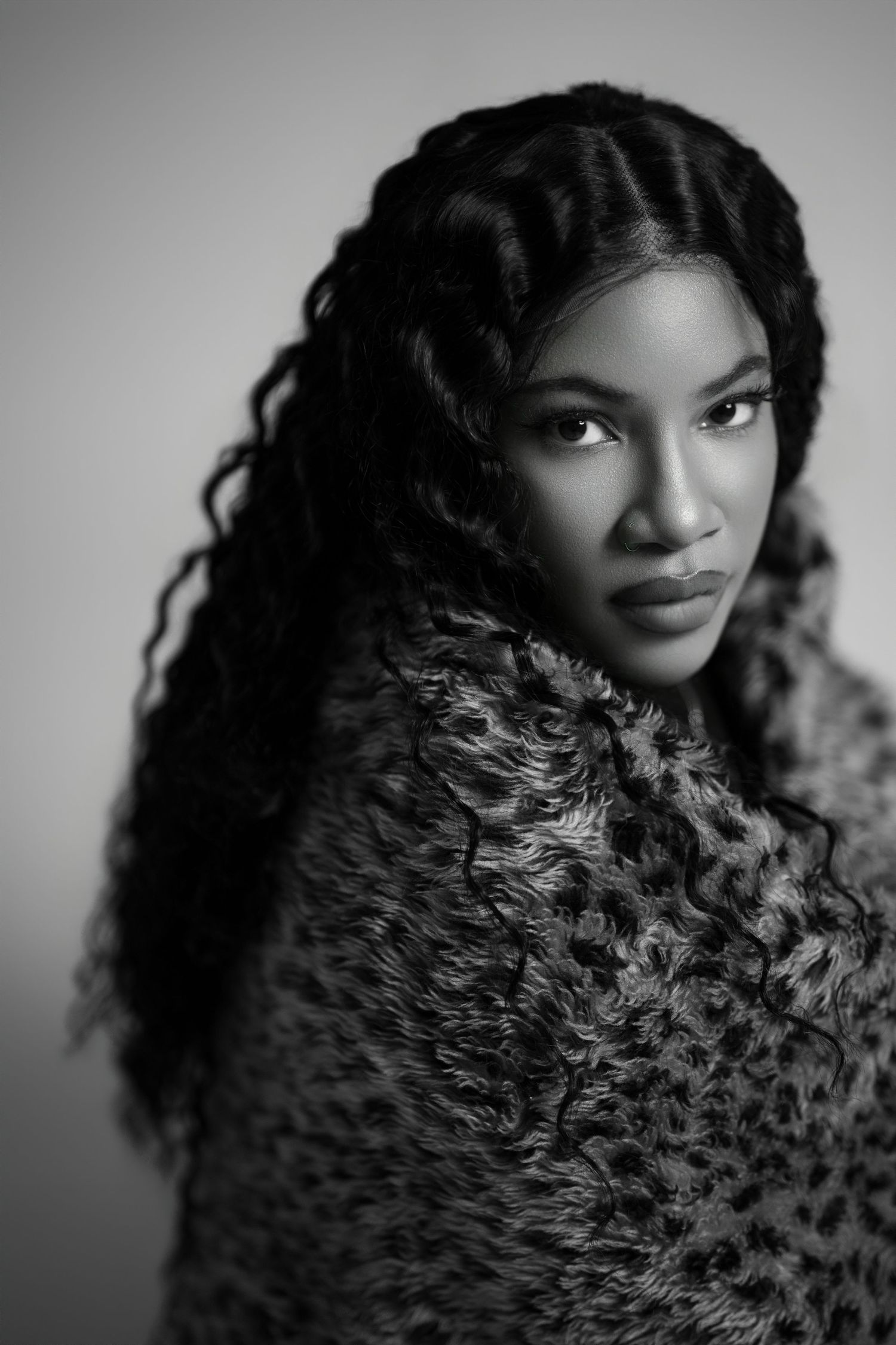 Black and white portrait series showing a doll with curly natural hair and expressive eyes in different angles.