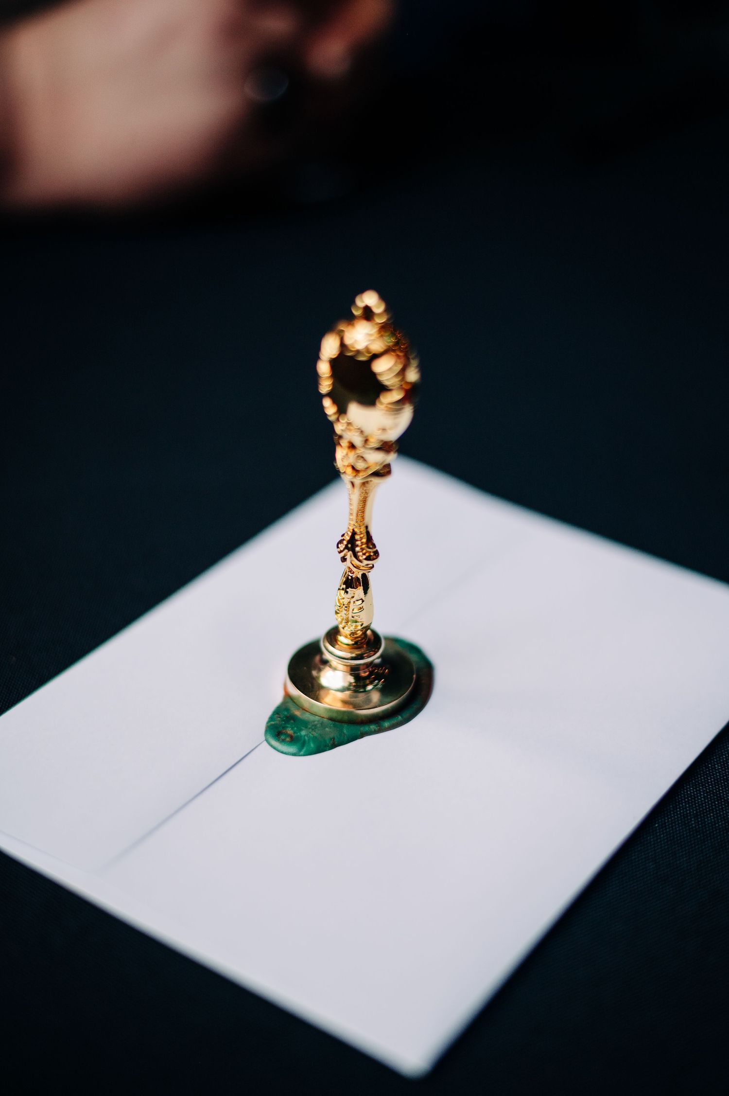 Golden chess piece knight figurine sits on white paper against dark background in artistic composition.