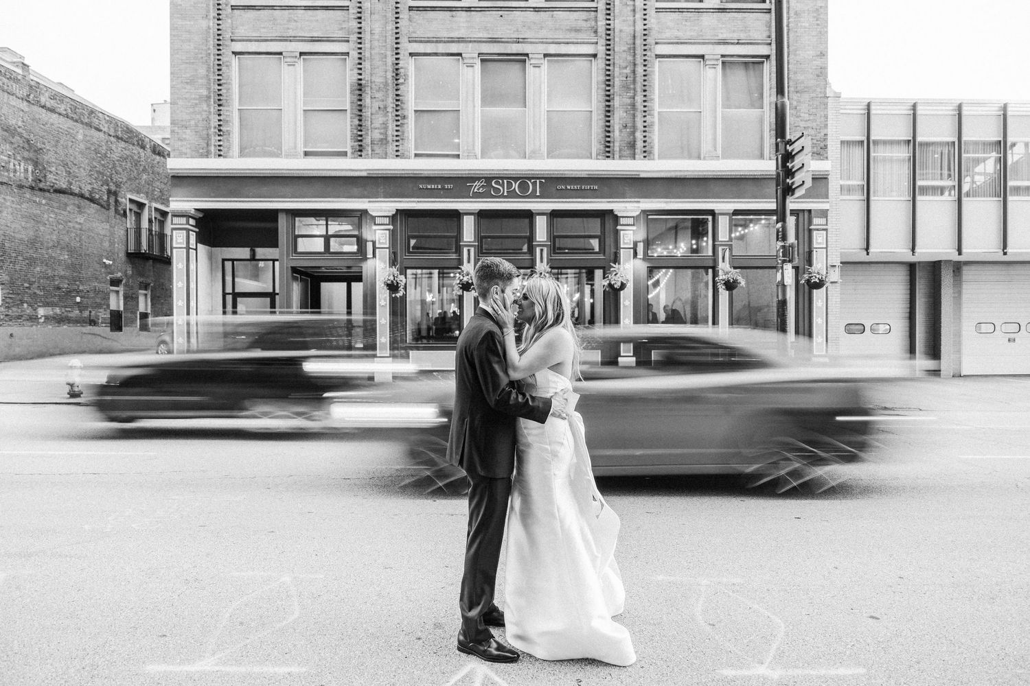 A black and white collage of wedding photos showing couples on a city street with vintage cars in the background.