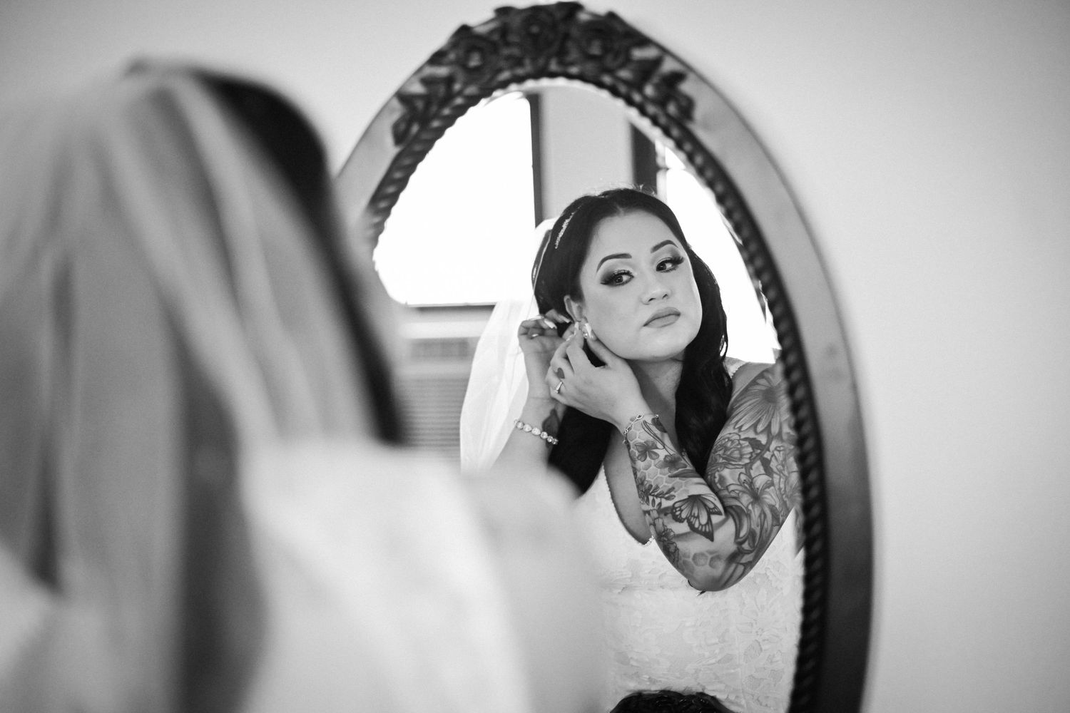 A reflection in an ornate mirror shows final wedding preparations being made.