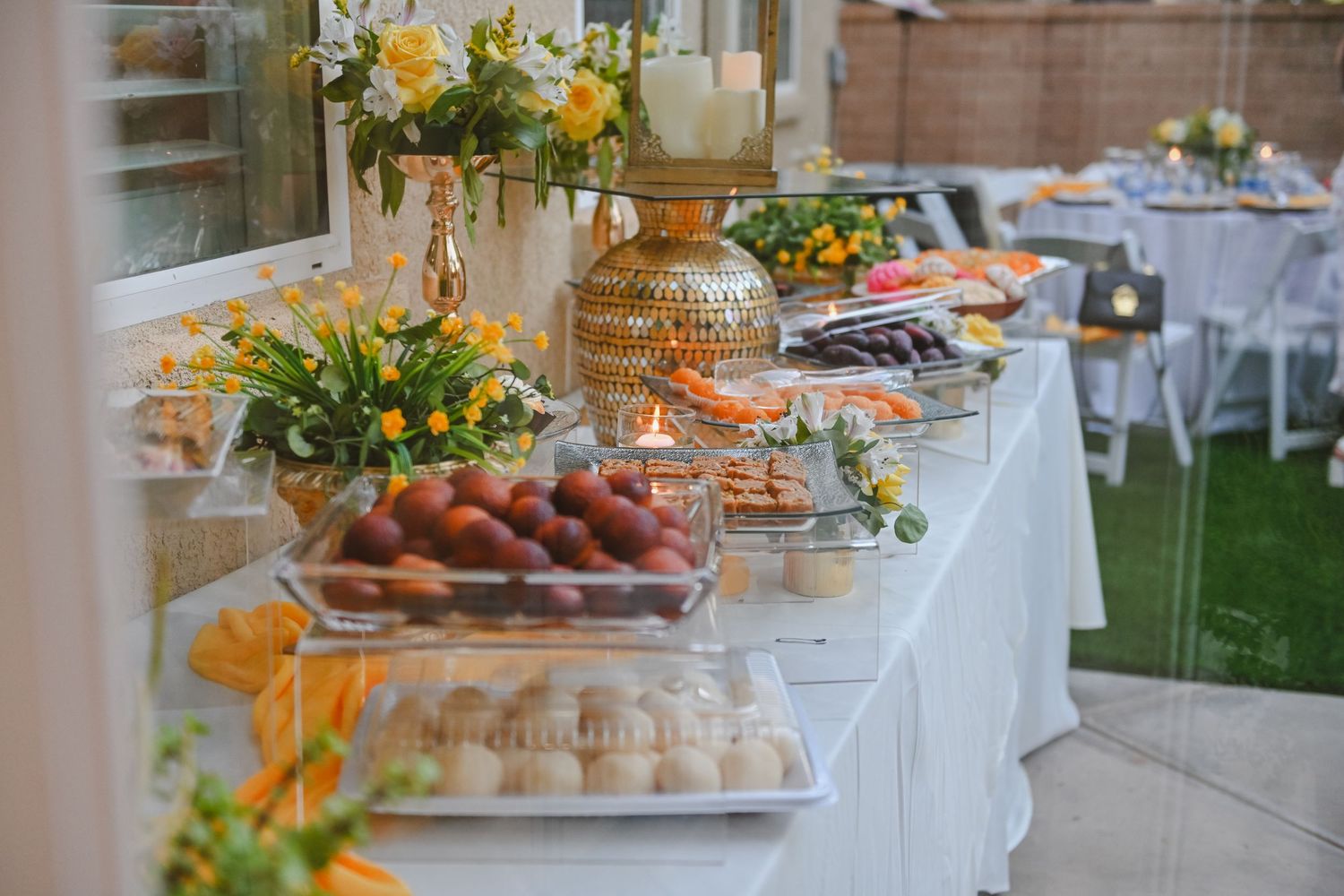 Elegant wedding buffet table with appetizers and floral decorations.