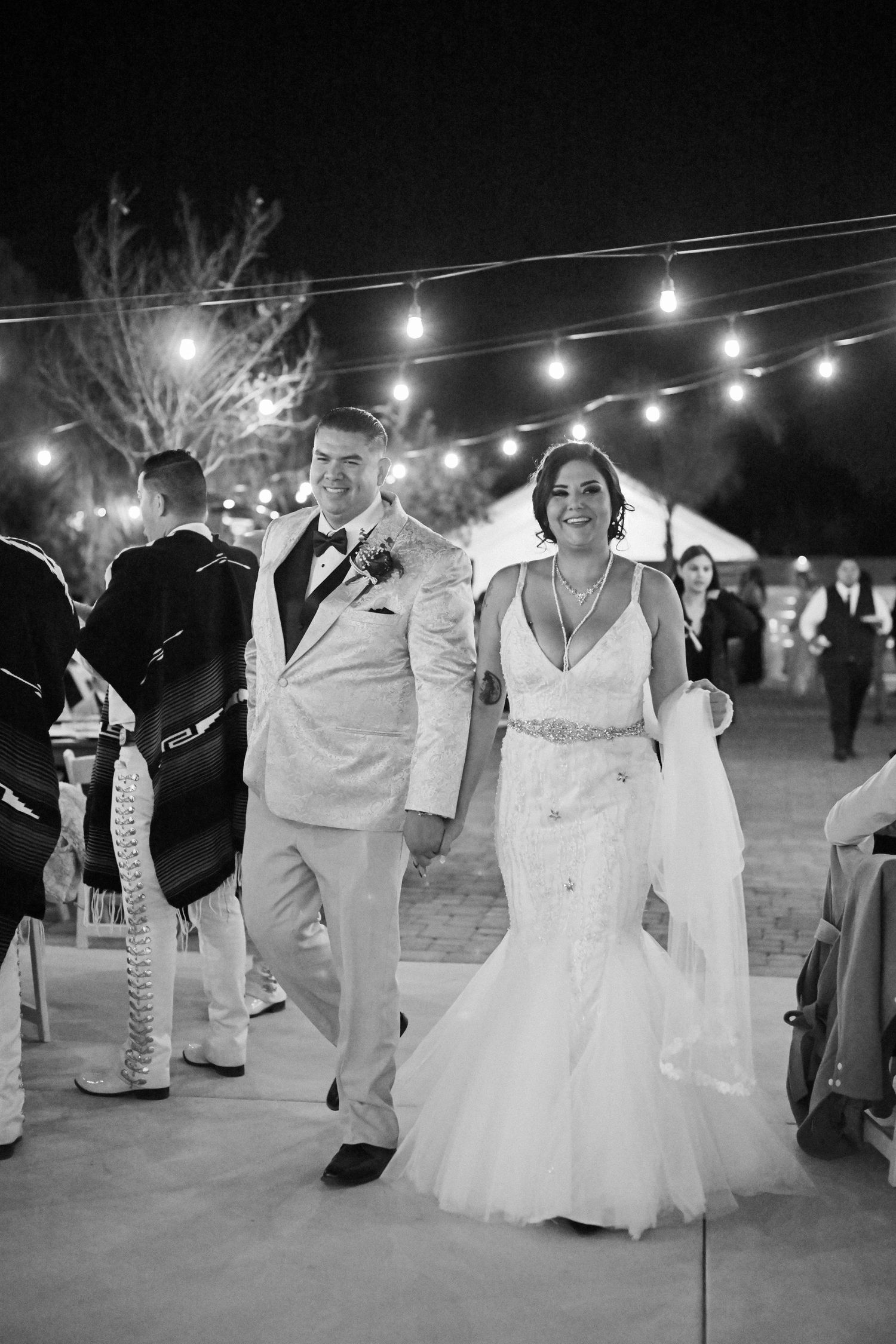 Wedding celebration under twinkling lights at an outdoor evening venue.