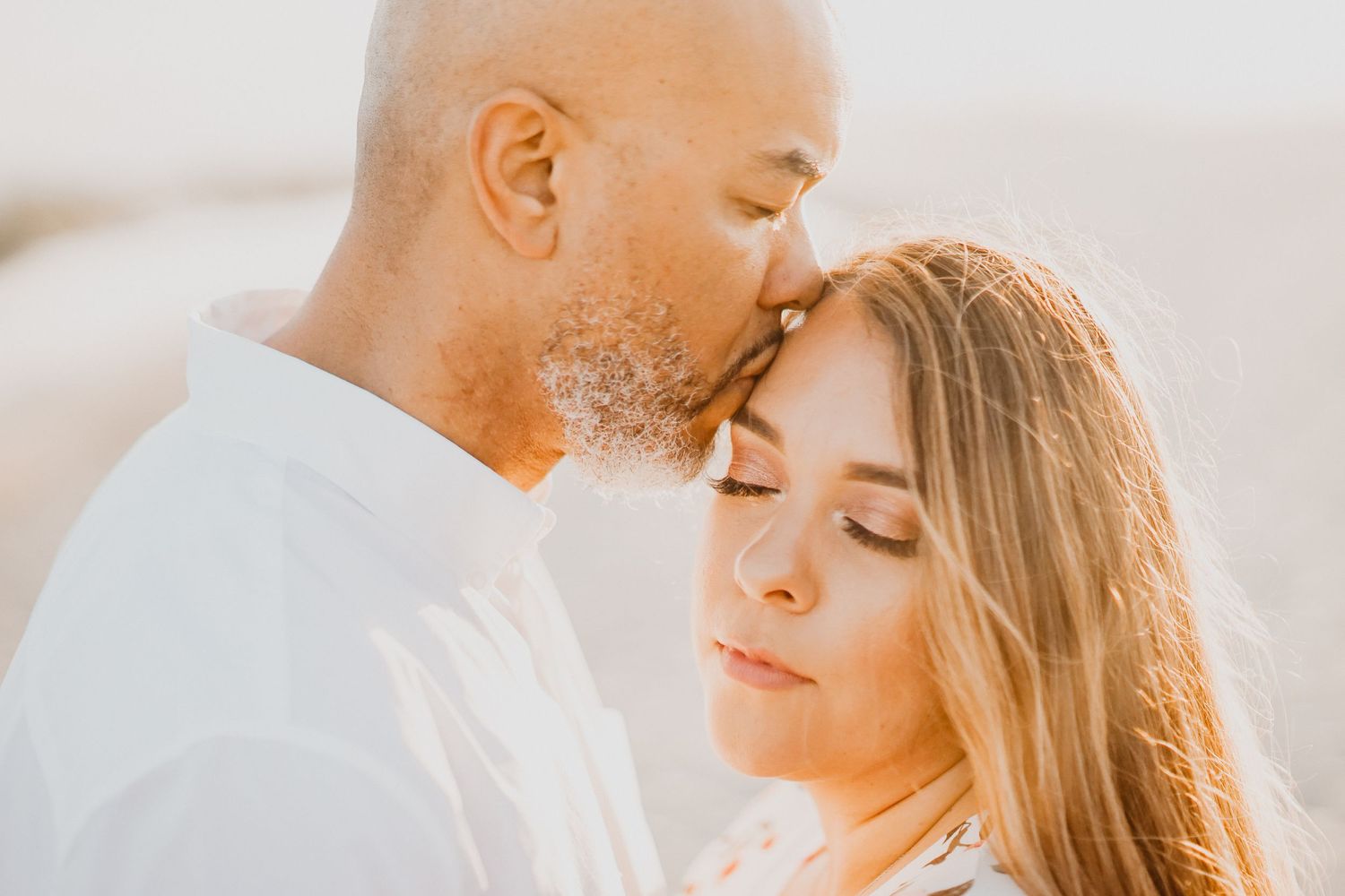 Intimate couple shares tender moment during golden hour photoshoot.