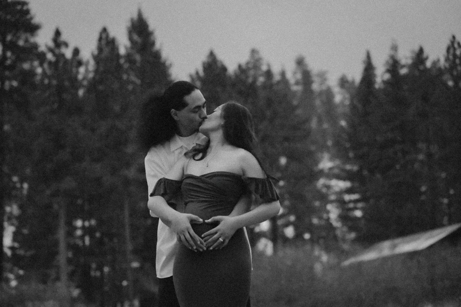 Romantic black and white portrait in a snowy forest setting.