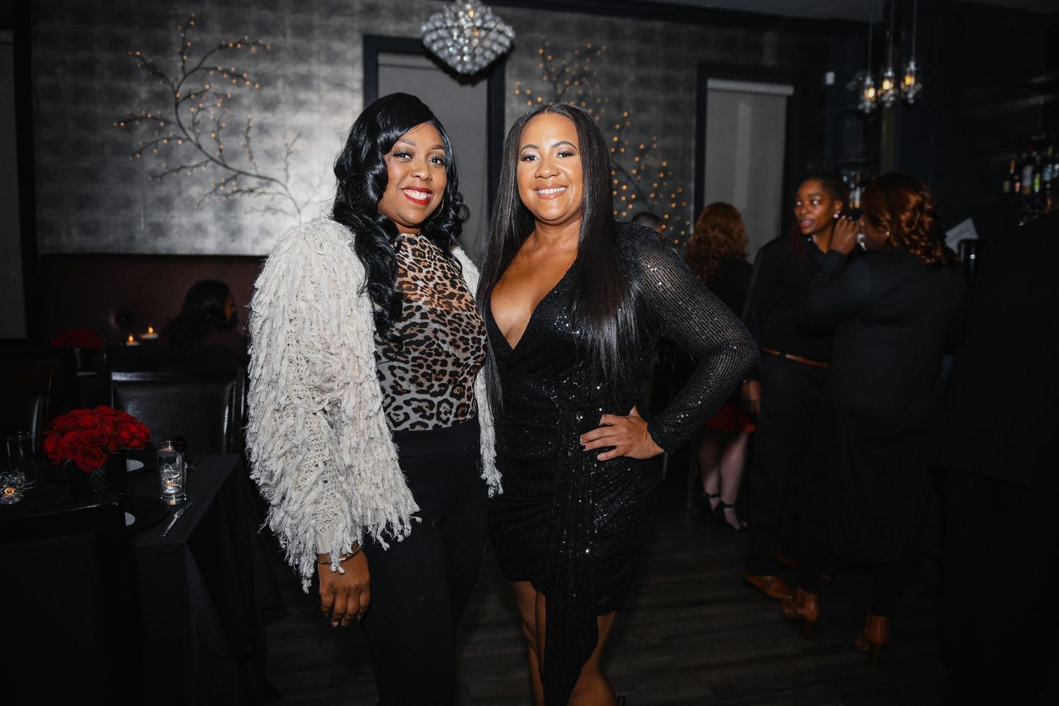 Two guests posing together at an elegant nighttime social gathering.