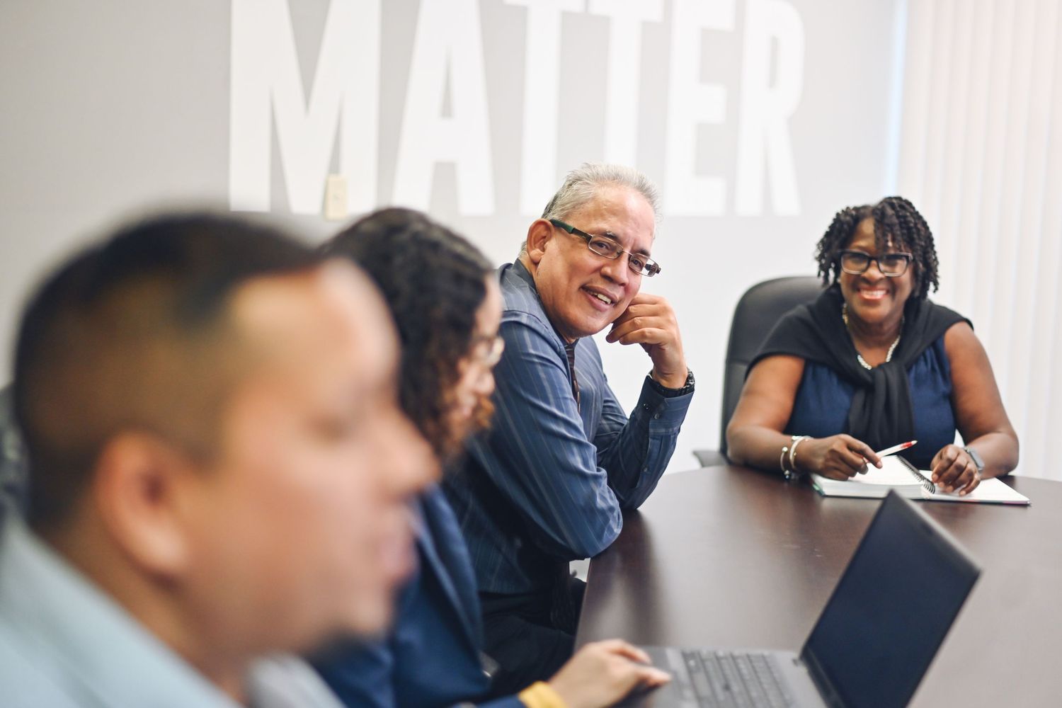 Colleagues collaborating during a business meeting in a modern office setting.