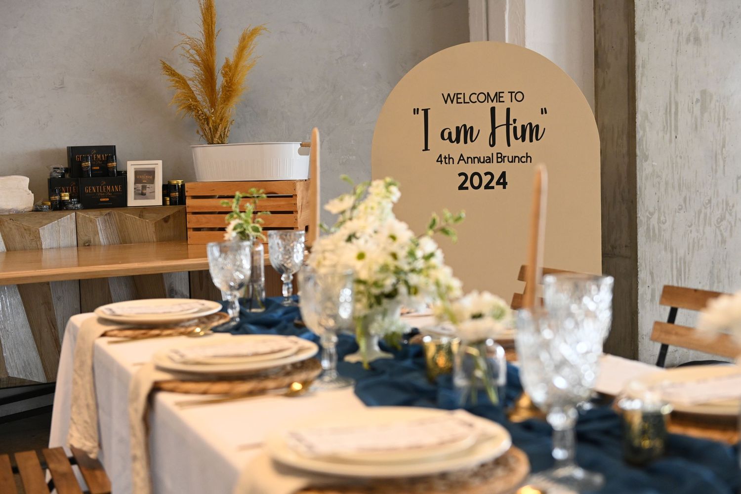 Wedding reception table with gold chargers and welcome sign reading 'I am Nine 2024'.