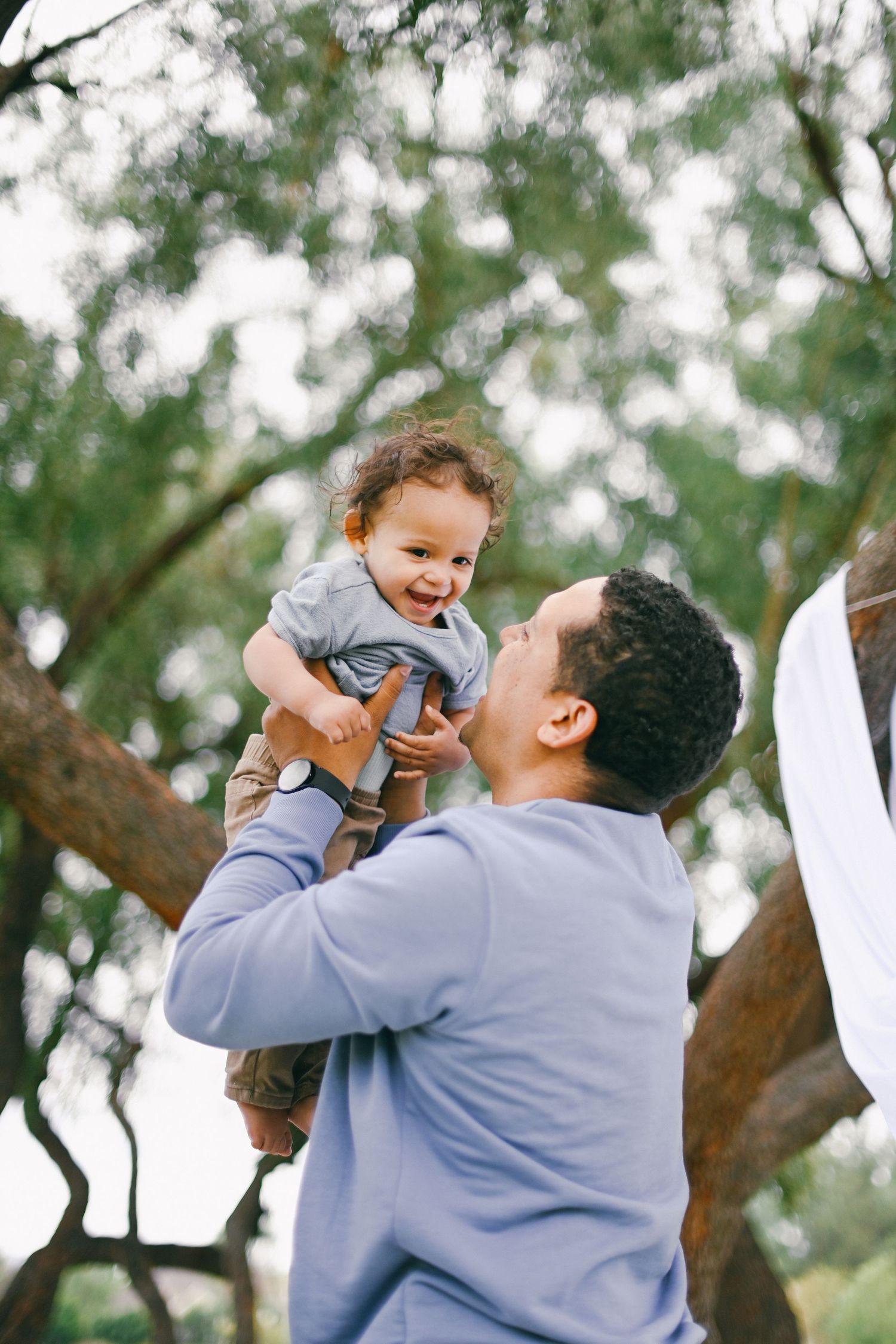 Joyful moment captured outdoors with trees in background.
