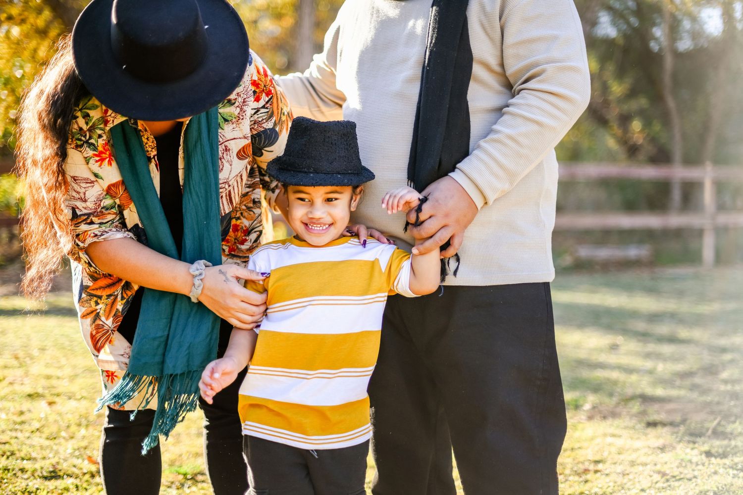 Family in casual attire spending time together outdoors on a sunny day.
