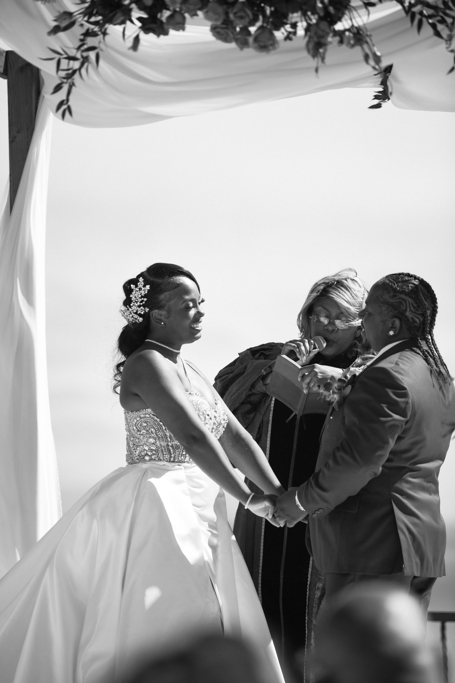 Black and white ceremony photo capturing an intimate moment during wedding vows.