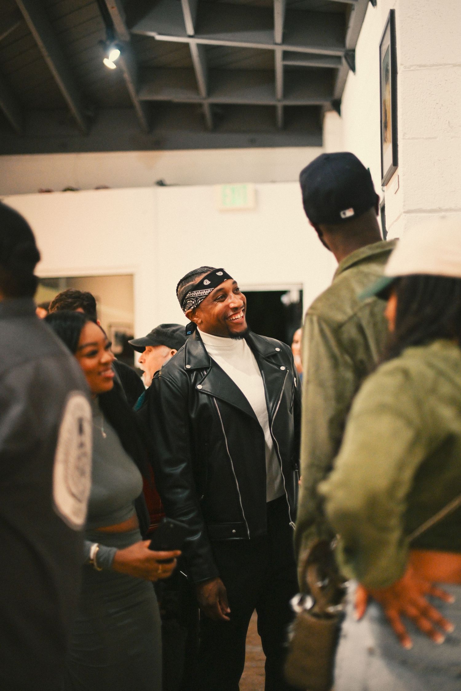 People socializing and mingling at an indoor art gallery event.