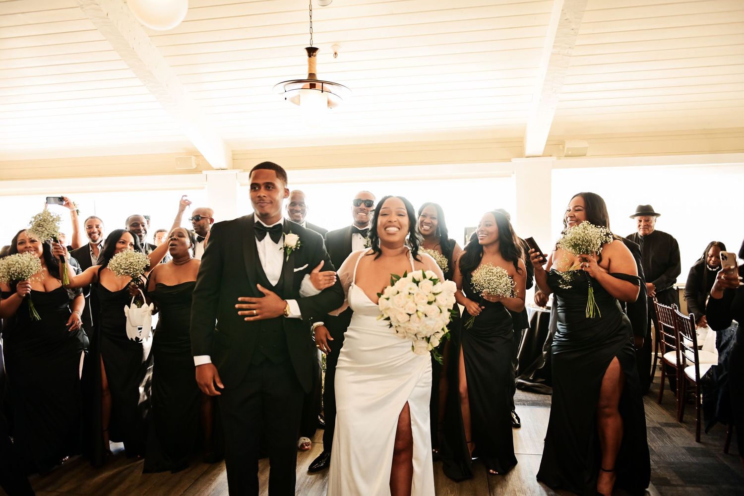 Jubilant wedding ceremony exit with guests clapping in celebration.