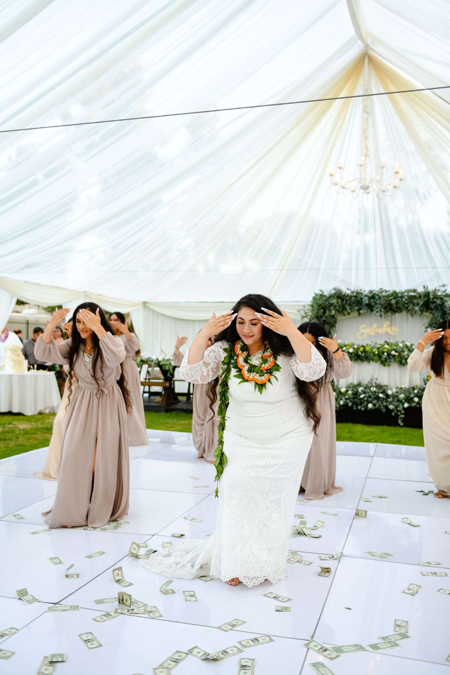 Wedding celebration with money dance tradition showing scattered bills on white dance floor.