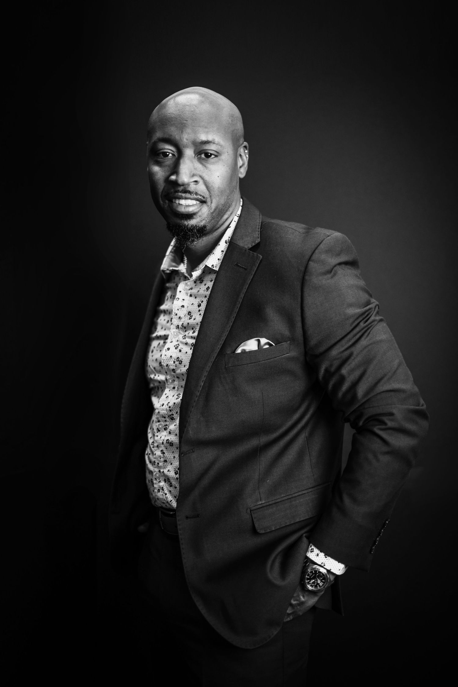 Elegant black and white portrait of person in floral shirt and blazer.