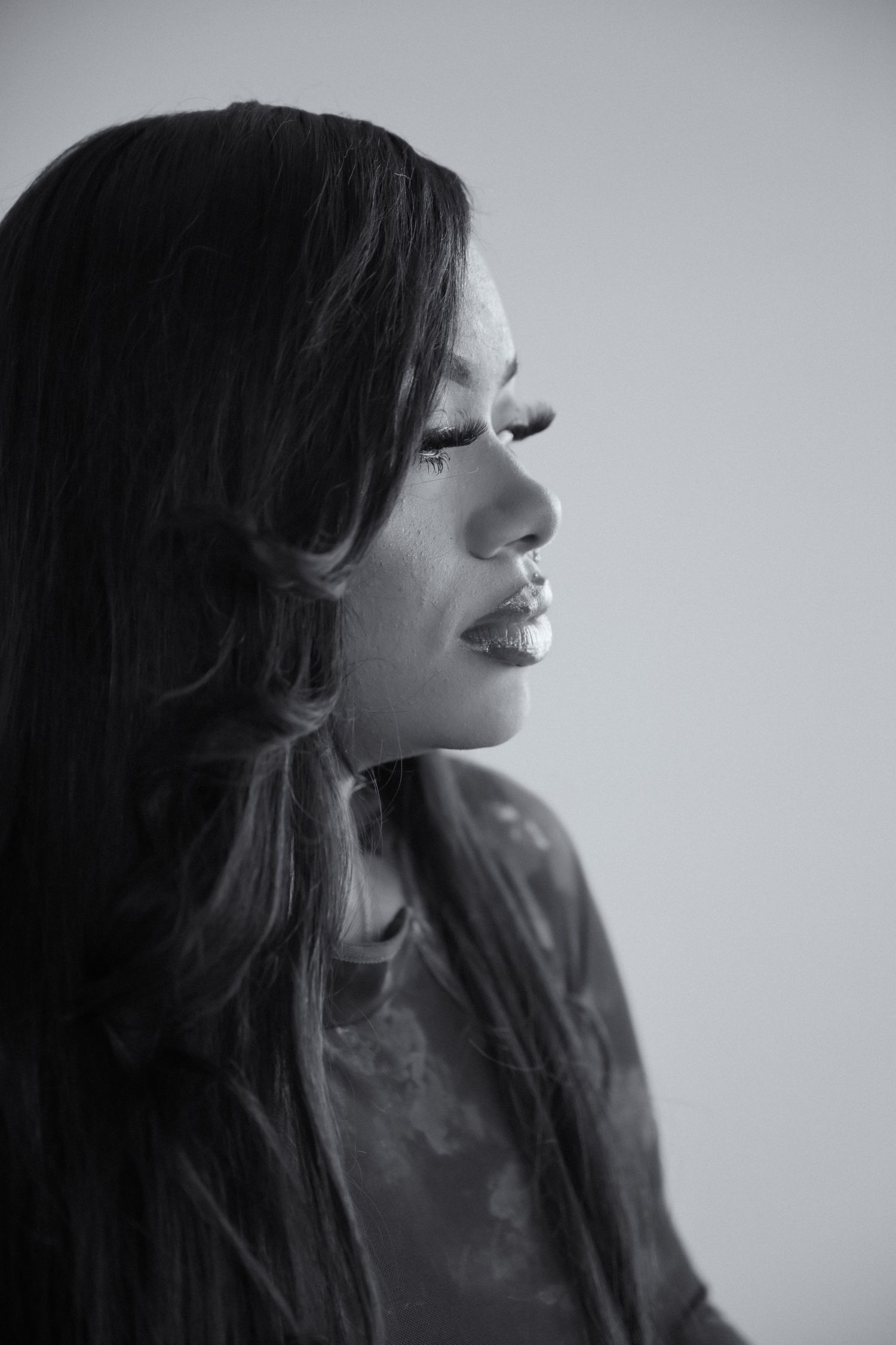 Black and white profile portrait of a person with long dark hair against a light backdrop.