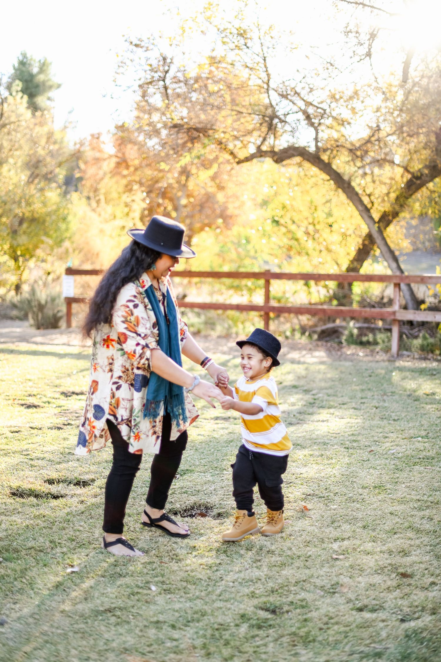 Playful outdoor scene with yellow striped shirt and floral dress during autumn.