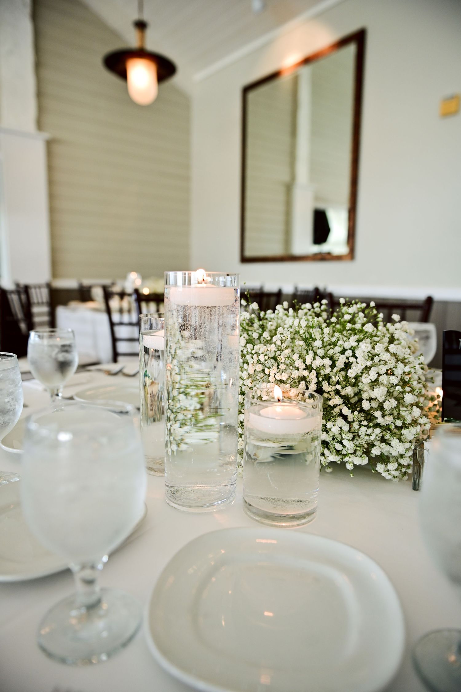 Elegant wedding table setting with baby's breath centerpiece and floating candles.