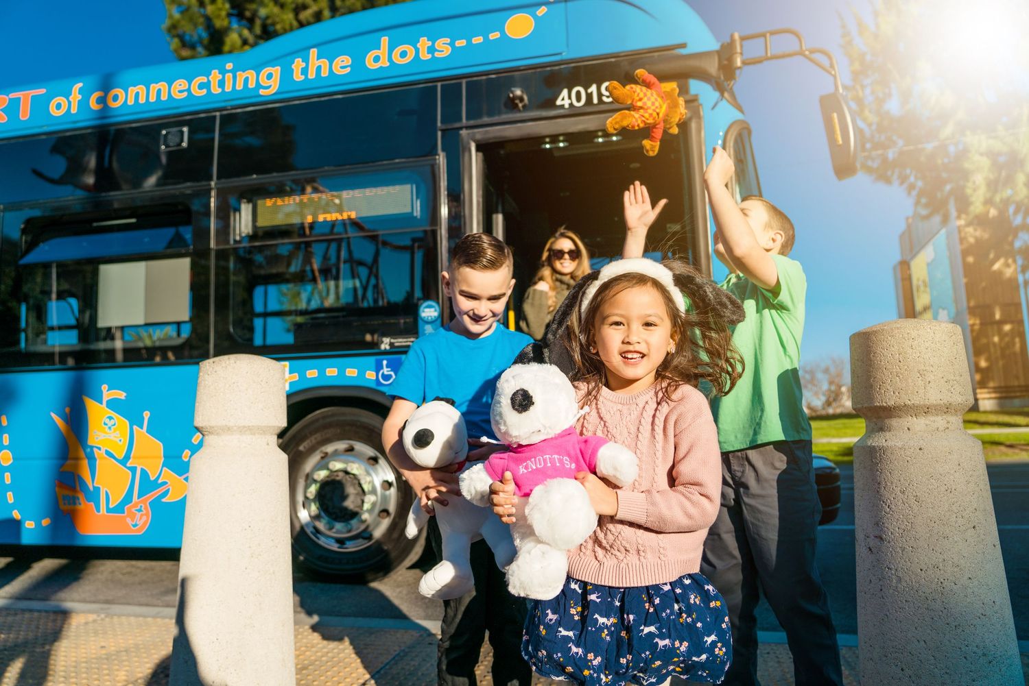 Children play in front of an Anaheim Resort bus