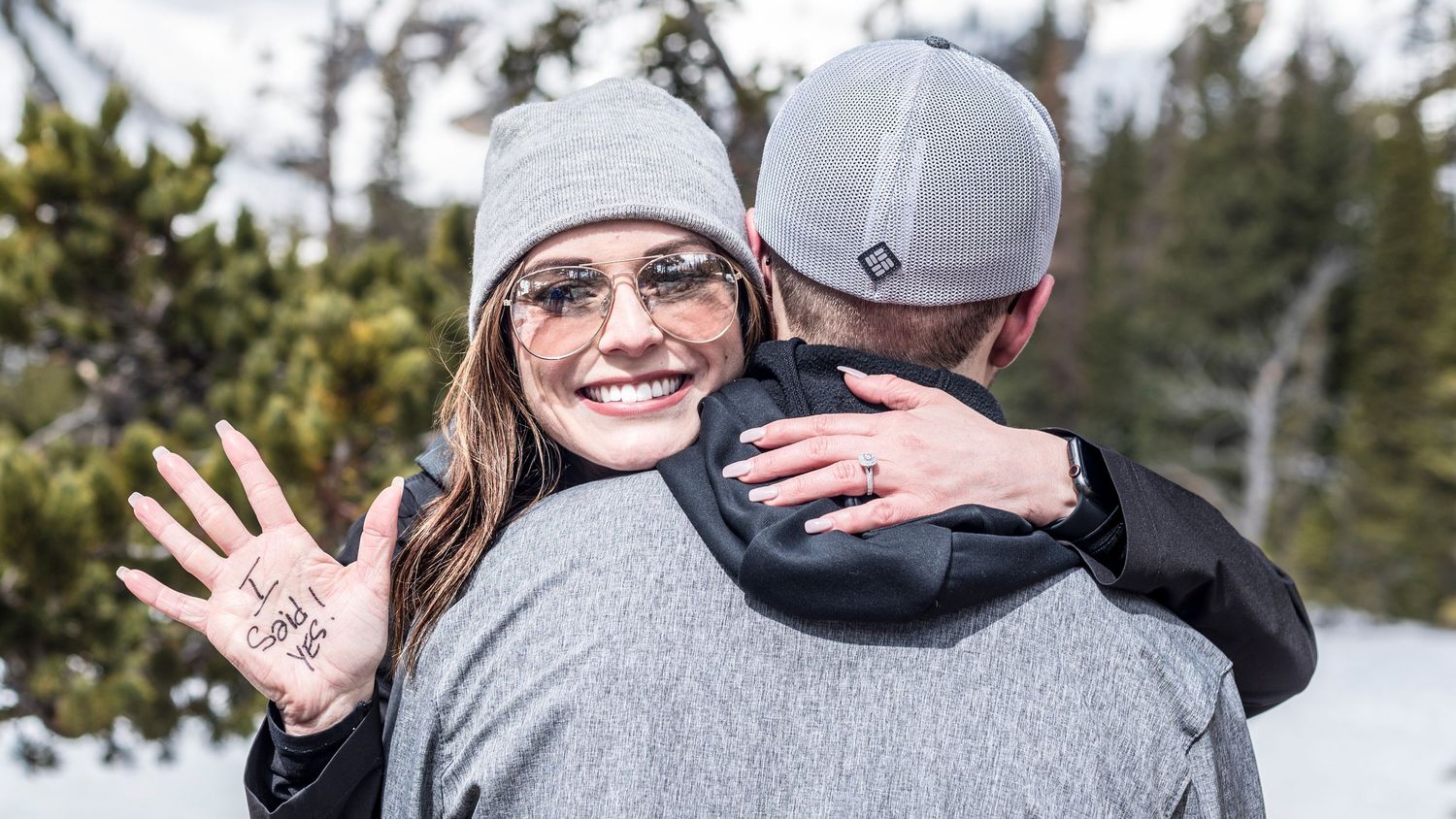 Newly engaged woman showing off her I SAID YES hand after her surprised her with a marriage proposal inside RMNP at Dream Lake.