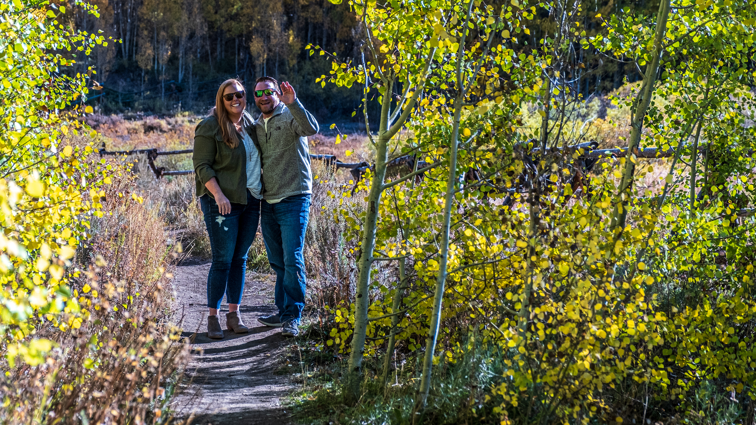 Couple smiling after she said yes to his surprise marriage proposal near Breckenridge, CO and the hidden photographer is revealed.
