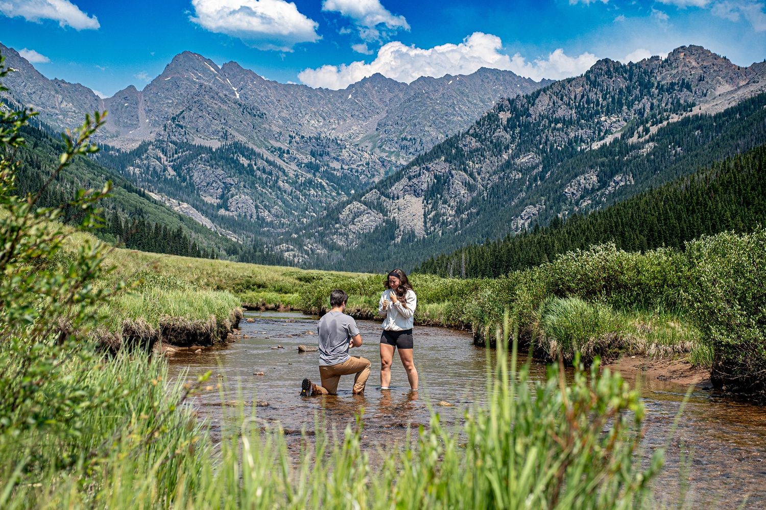 Hidden photographer captures a man down on one knee in the middle of a river for this marriage proposal near Vail, CO