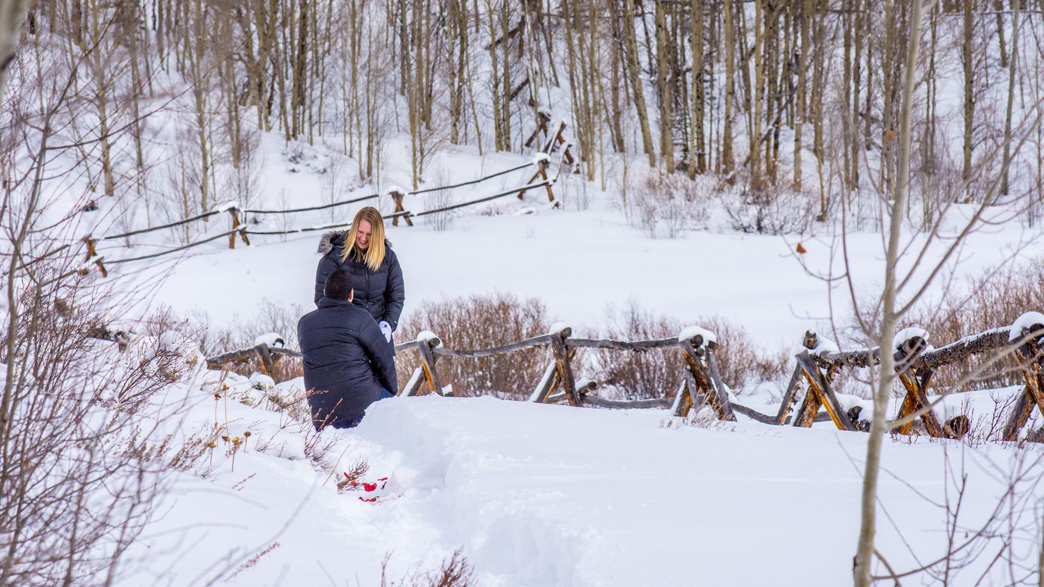 Man down on one knee during this surprise marriage proposal at Aspen Alley in the winter near Breckenridge, CO