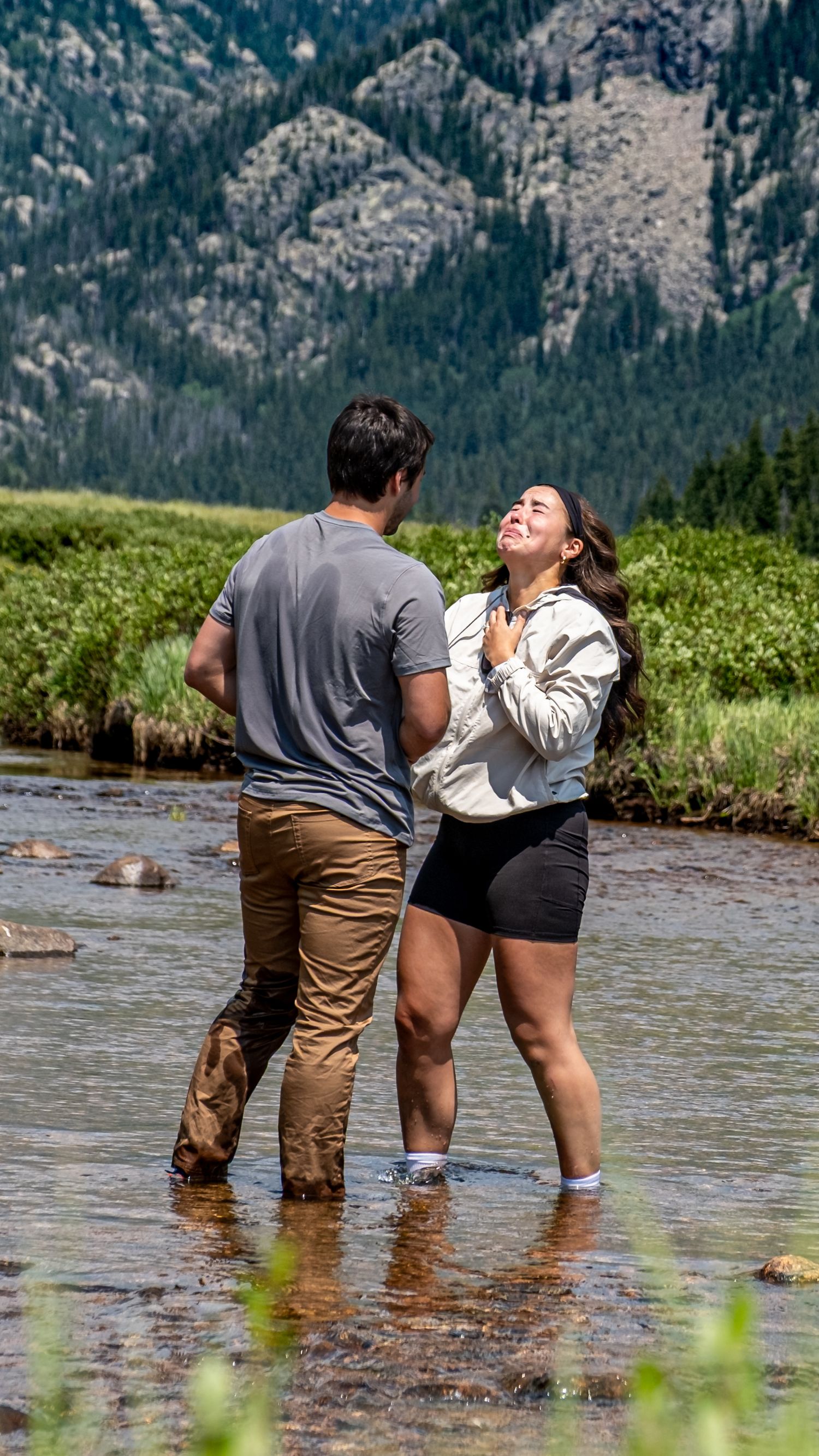 A couple standing in the middle of Piney River near Vail, CO moments after a surprise marriage proposal here in the Colorado Rocky Mountains