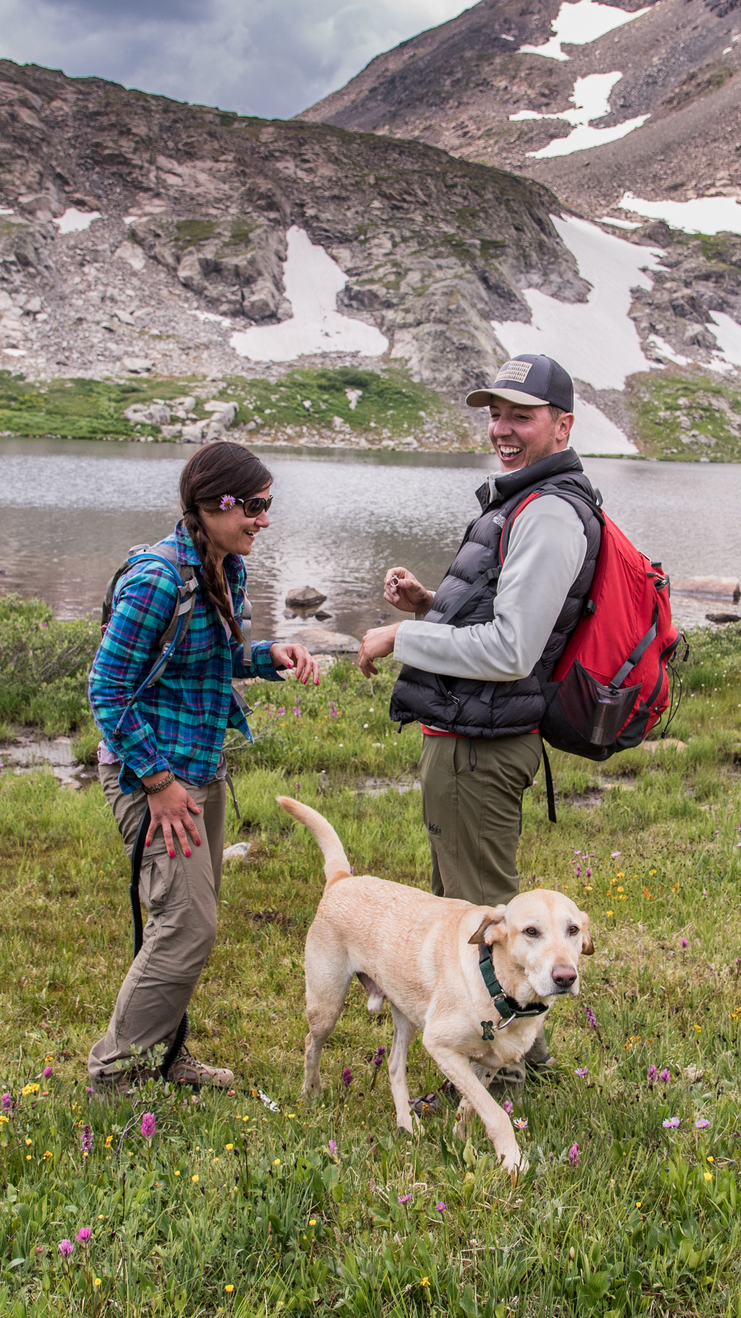 Couple with dog laughing after a surprise marriage proposal near Breckenridge, CO
