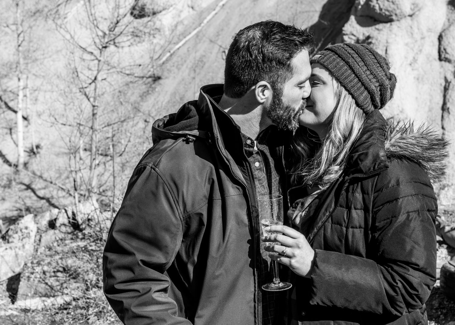 Couple kissing and showing off the fresh engagement ring in Breckenridge, CO while a hidden photographer captured the engagement.