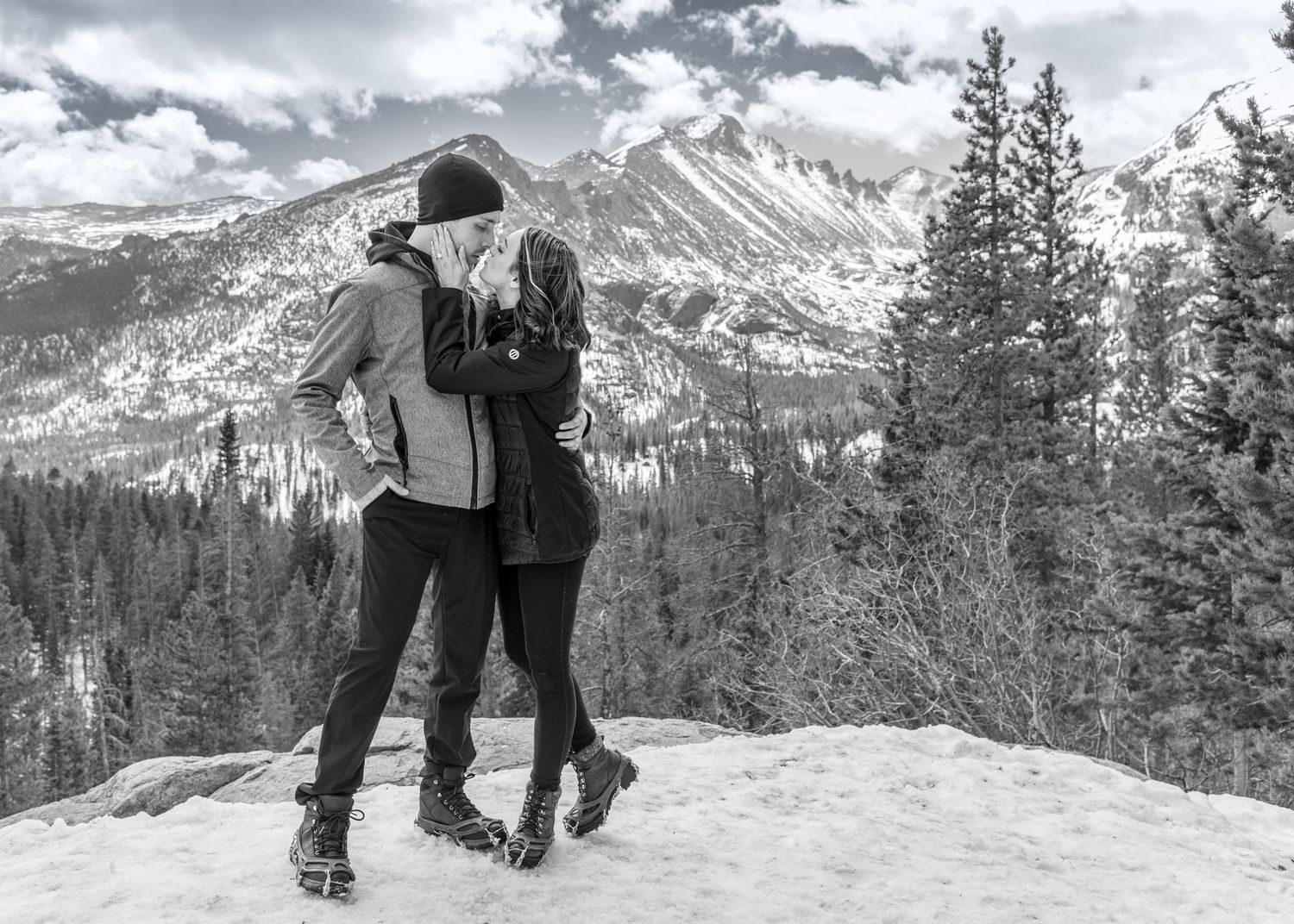 Couple embracing in the snow inside RMNP at Dream Lake after their surprise marriage proposal .