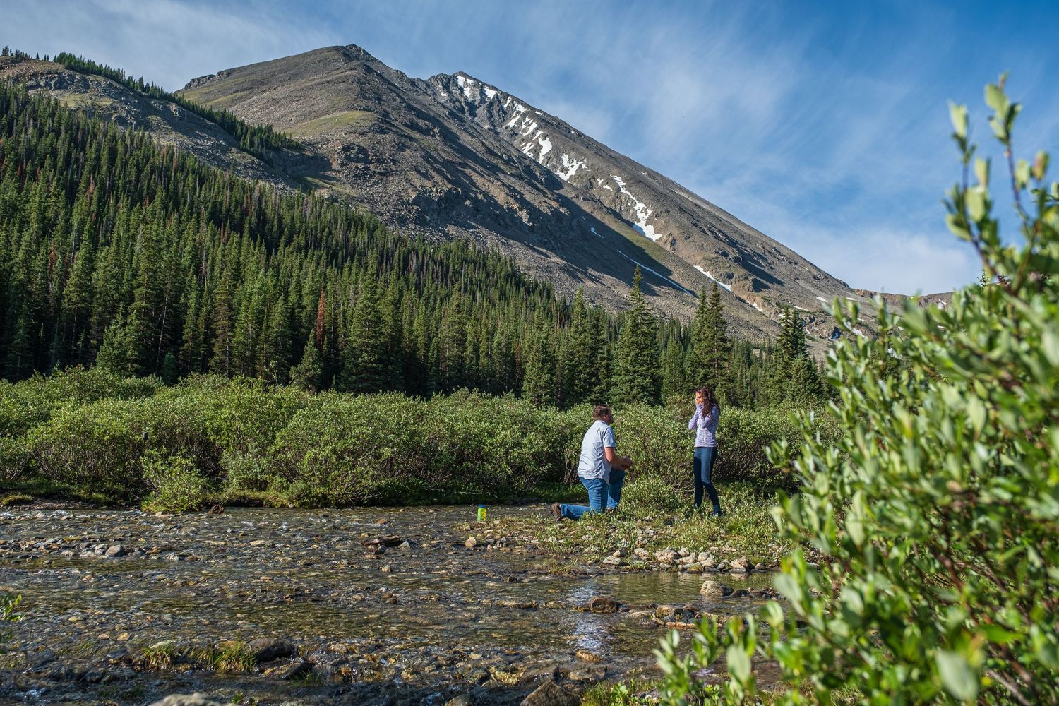 Man proposing near Breckenridge, Colorado as hidden photographer captures surprise moment she says yes.