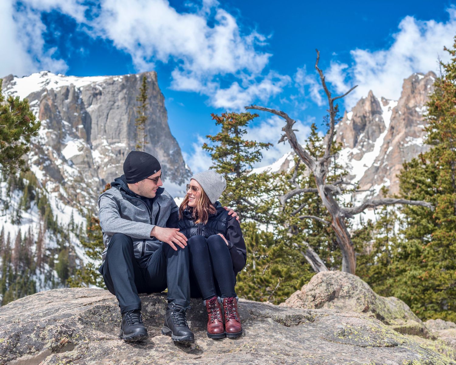 Couple quietly enjoying each other in RMNP Dream Lake after their surprise marriage proposal .