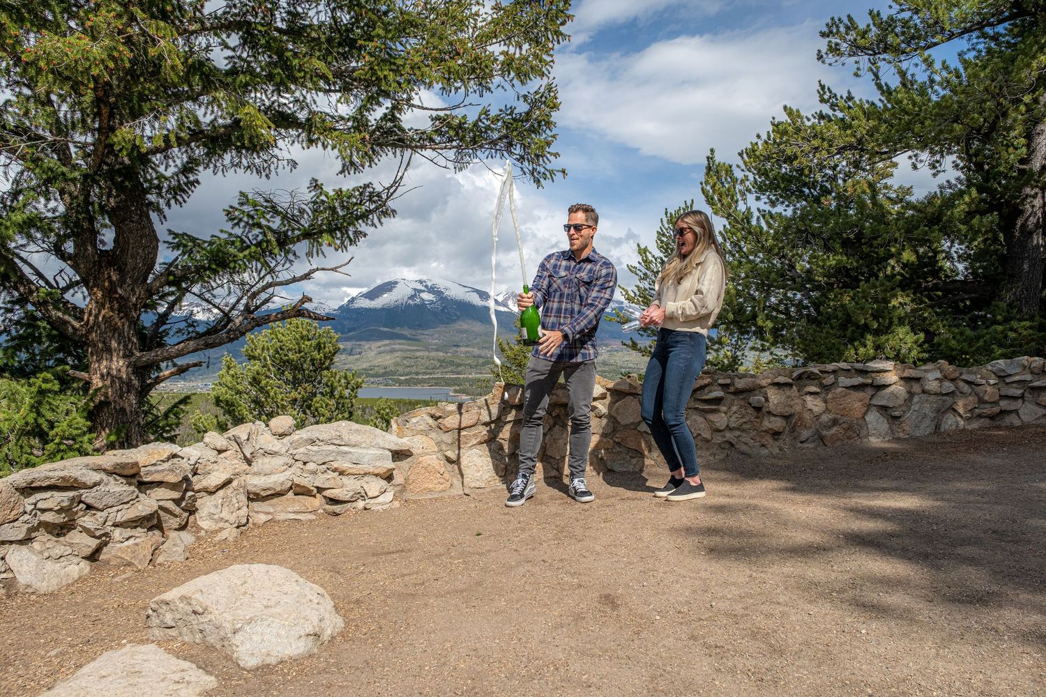 Popping champagne after she said yes to his surprise marriage proposal at Sapphire Point Overlook near Breckenridge Colorado (summer)