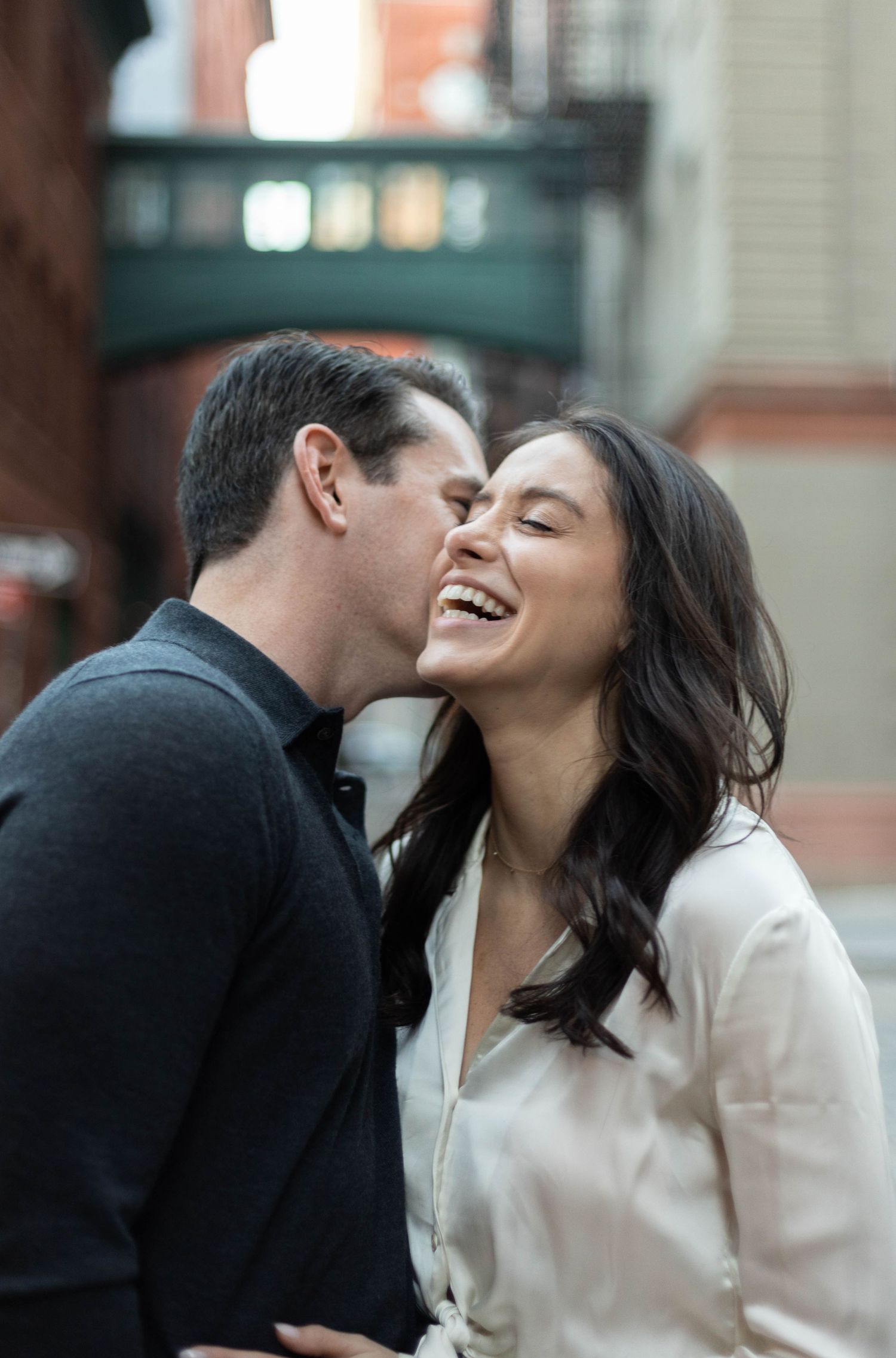 A candid moment of shared laughter outside a brick building.
