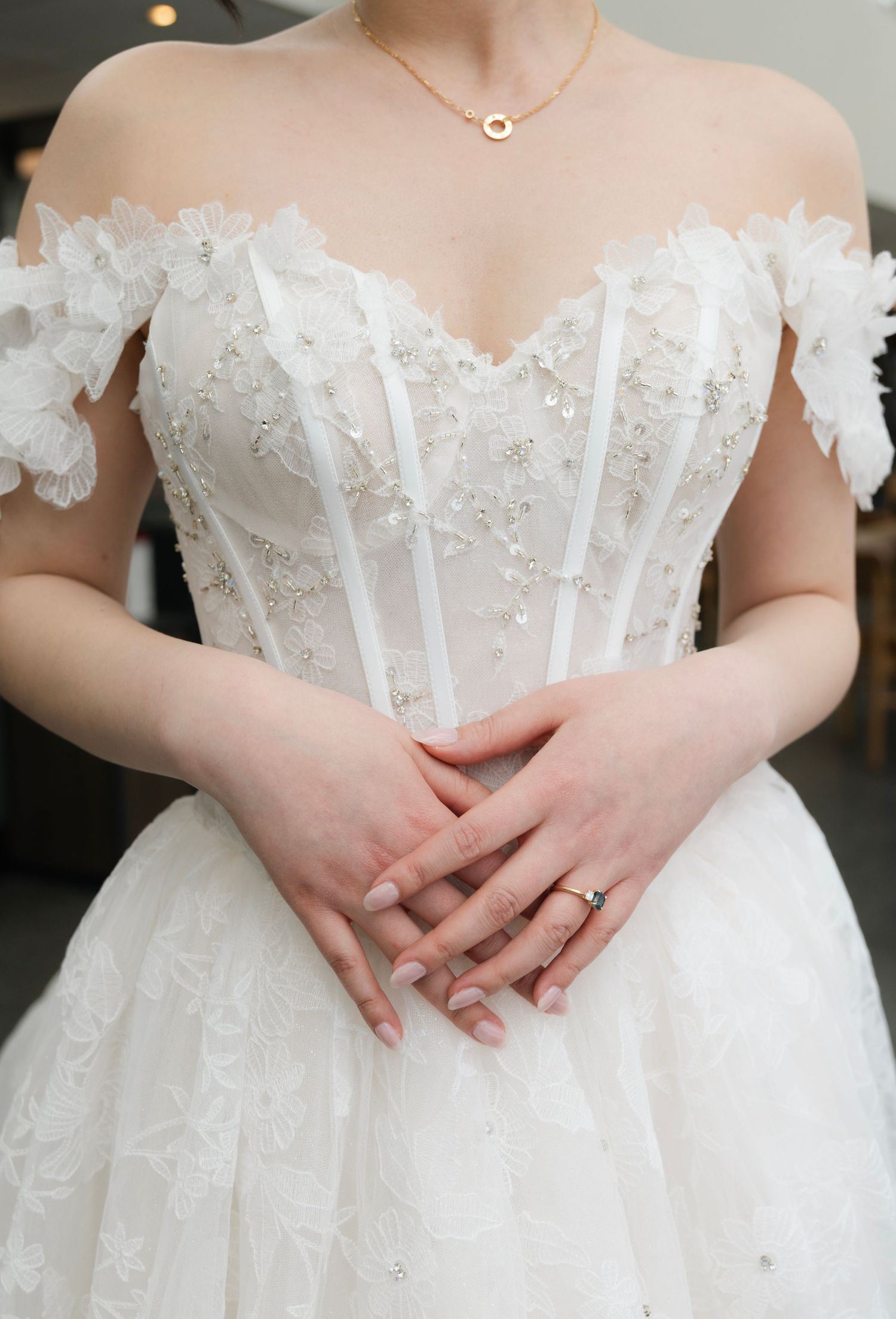 Close-up shots of a stunning white wedding dress with intricate lace details and off-shoulder design.